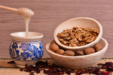 Honey pouring into the painted vintage cup and walnuts