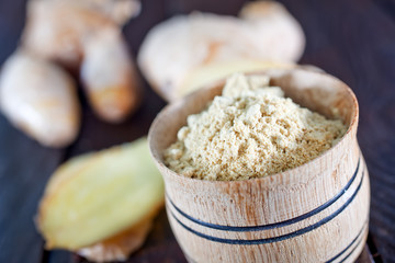 dry ginger in the wooden bowl and on a table