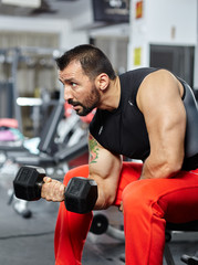 Fototapeta na wymiar Man doing biceps workout in a gym
