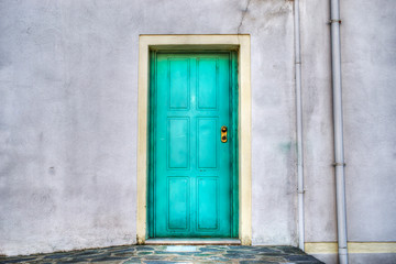 turquoise door in a grey wall