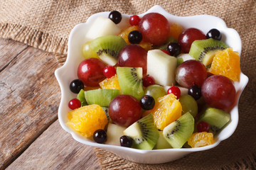 Fruit salad of oranges, grapes. pears, kiwis closeup. Horizontal