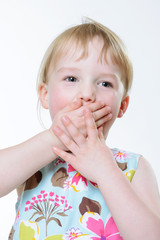 Lachendes M&auml;dchen mit H&auml;nden vorm Mund