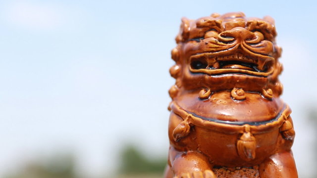 Footage of Chinese lion statue with blue sky