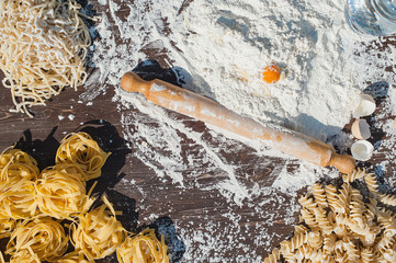 Pasta egg in flour and a rolling pin.