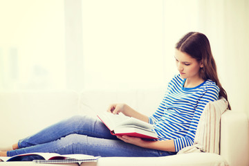 calm teenage girl reading book on couch