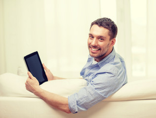 smiling man working with tablet pc at home