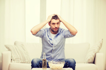 sad man watching sports at home