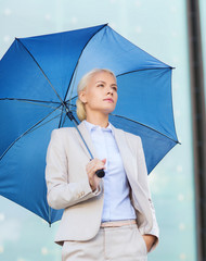 young serious businesswoman with umbrella outdoors