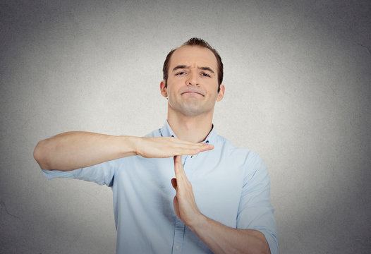 erious confident business man showing time out gesture
