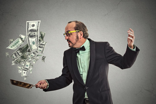 Middle age businessman juggling money dollar bills