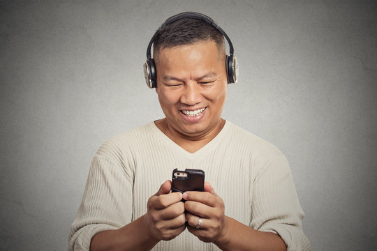 smiling young man listening music on cell phone