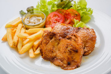 Chicken steak served with french fries and salads to vegetables
