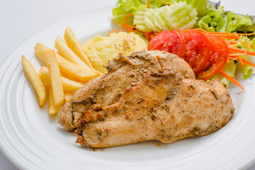 Pork steak with french fries and salad on a white background.
