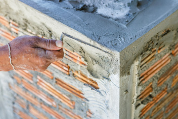 plasterer concrete worker at wall of house construction