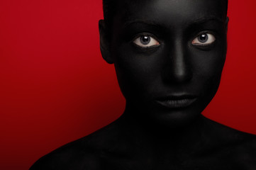 close-up portrait of woman in black paint