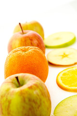 line of apples and slices with one orange