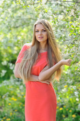 Naklejka na ściany i meble Beautiful young blonde woman in spring on a warm sunny day