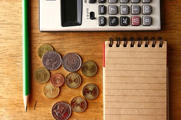 Notebook, calculator, pencil and coins