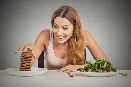 woman deciding to eat healthy food or sweet cookies she craving