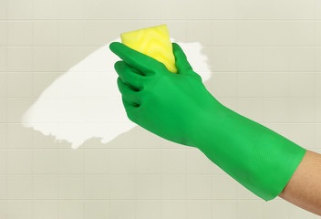 Hand in green glove with sponge