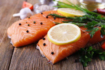 Fresh salmon with spices and lemon on wooden table