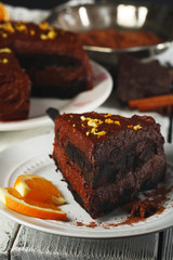 Chocolate cake with chocolate cream on wooden table close-up