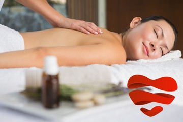 Composite image of content brunette getting a back massage