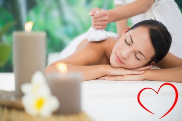 Obraz na płótnie Canvas Beautiful brunette enjoying a herbal compress massage
