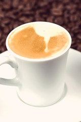 Close view on cup of expresso with roasted coffee beans