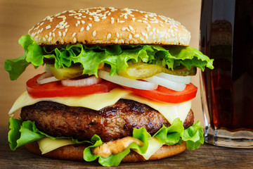 Burger with cola on wooden table