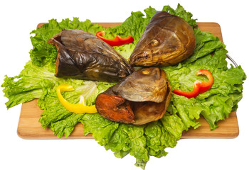 smoked fish heads with salad and pepper on chopping board