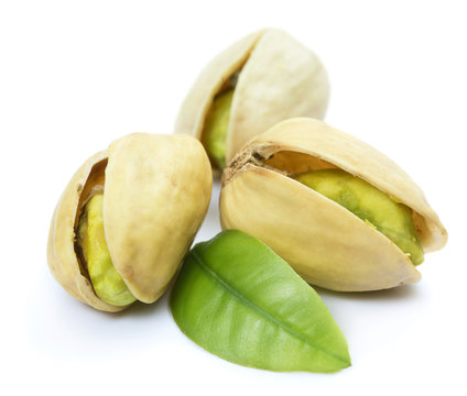 Three pistachio nuts with leaf