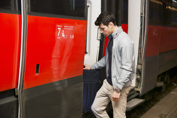 Handsome young man getting aboard on train