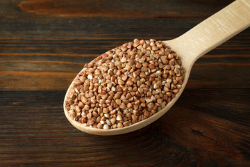 Buckwheat in a wooden spoon on wood