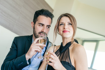 Elegant Young Couple Cheering at Hotel Suite
