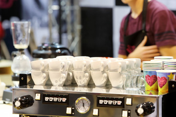 White cup of coffee at the coffee machine and barista