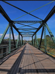 Fototapeta na wymiar Narrow long bridge with symmetrical metal structure