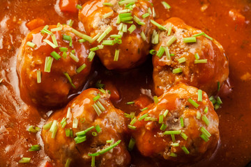 Meatballs with tomato sauce on black pan