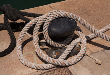 Fototapeta na wymiar Rusty mooring plate knob and ropes