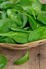 spinach in a basket on wooden surface