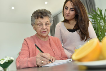 Young woman visiting elderly woman in nursing home