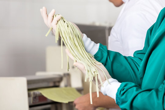 Male Chef Holding Spaghetti Pasta At Kitchen