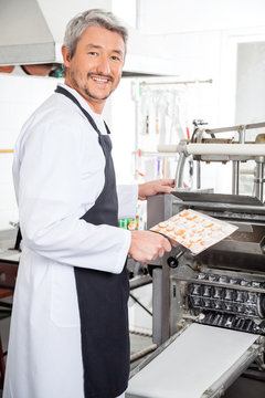 Happy Chef Using Ravioli Pasta Machine At Kitchen