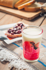 Strawberry Jam, bread and milk on the table background