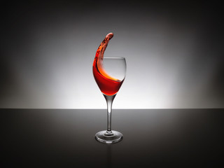 Red wine pour into glass over black background