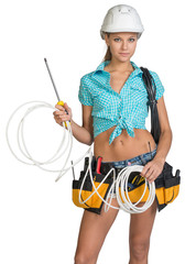 Pretty electrician in helmet, shorts, shirt, tool belt with