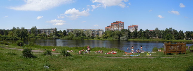 Panoramic cityscape with lake and sun bathers