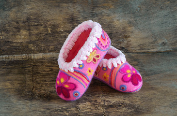 baby pink slippers  on the wooden background