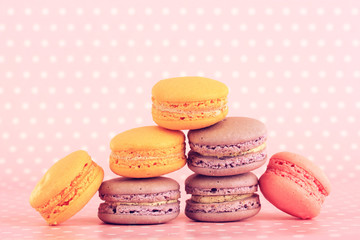 Tasty macaroons on pink polka dot background