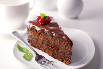 Delicious chocolate cake on plate on table on light background